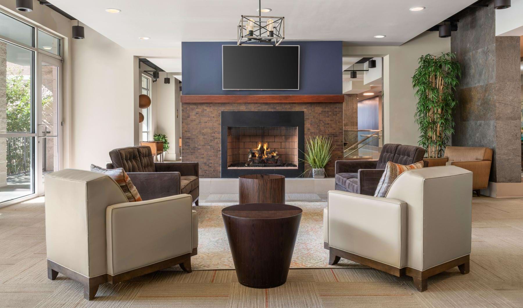 a clubroom with chairs, a tv and a fireplace