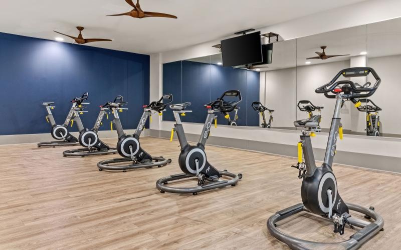 a fitness studio with bikes and a tv