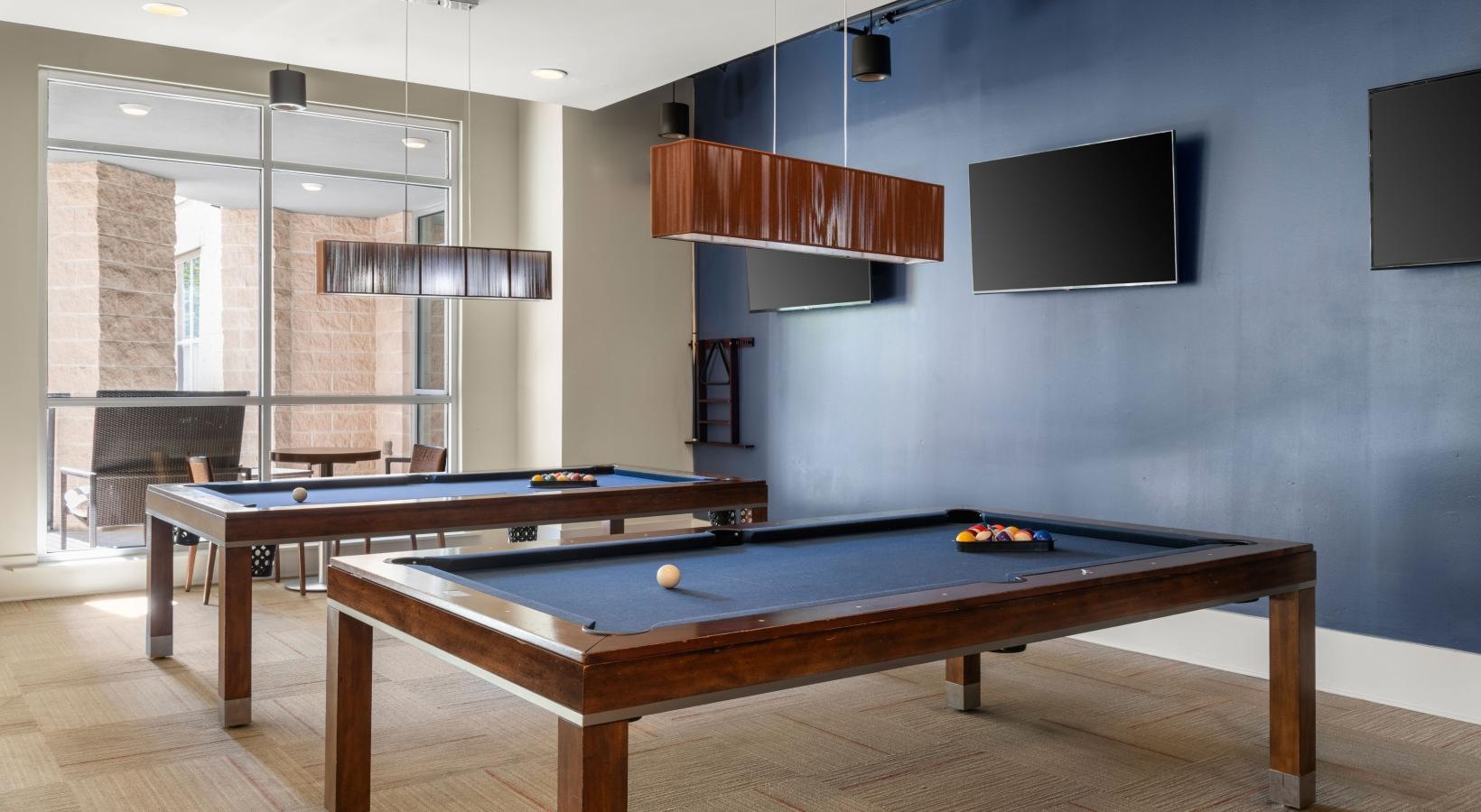 a room with pool tables and tv's